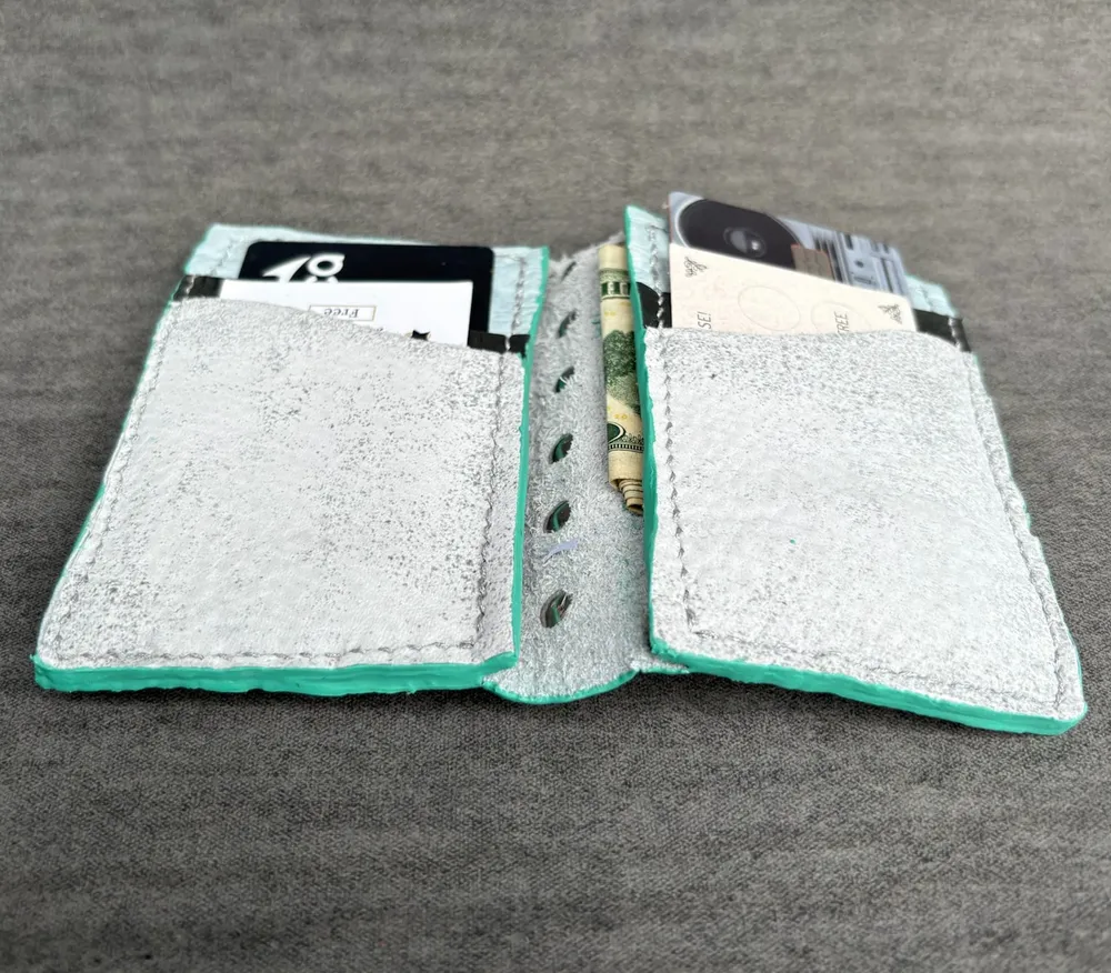 Wallet opened flat with all pockets full, viewed at an angle