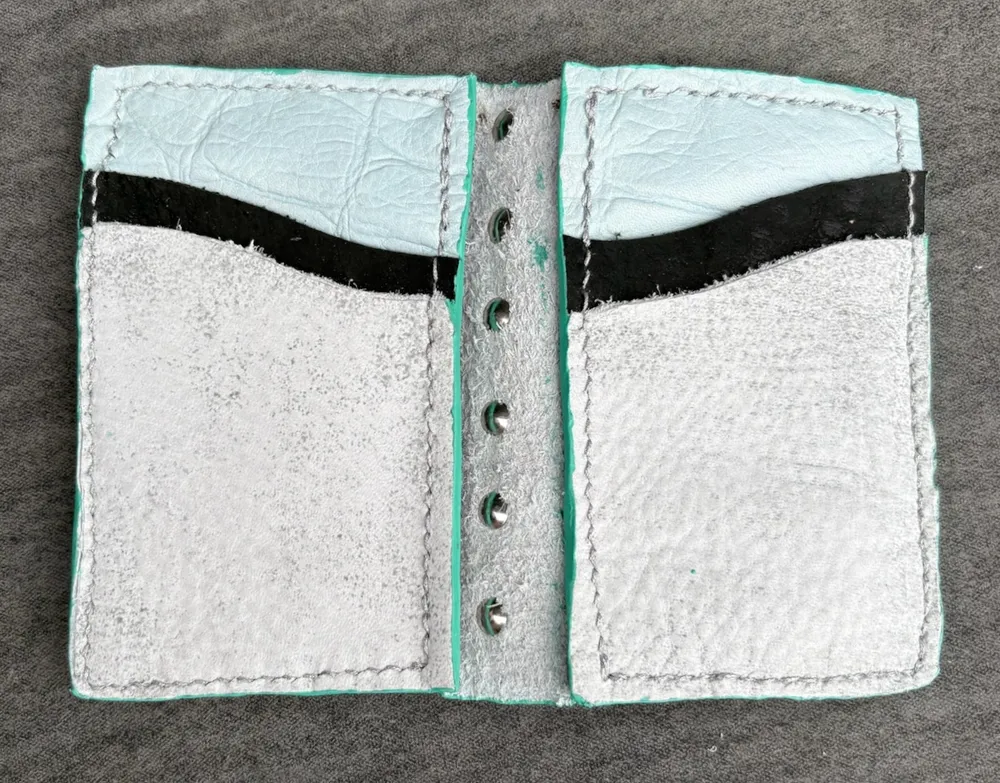 Wallet opened flat and empty, showing some edge paint that has gotten on the inner spine